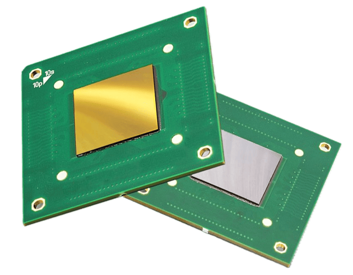 Two green circuit chips with reflective gold and silver square components mounted on them.