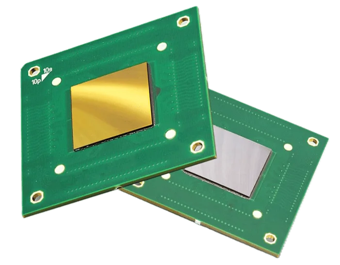 Two green circuit chips with reflective gold and silver square components mounted on them.